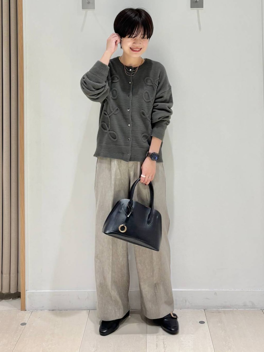 ブラック系のローファー、ブラック系のショルダーバッグ、ベージュ系のその他パンツを着用したレディースの秋コーディネートの5枚目の写真