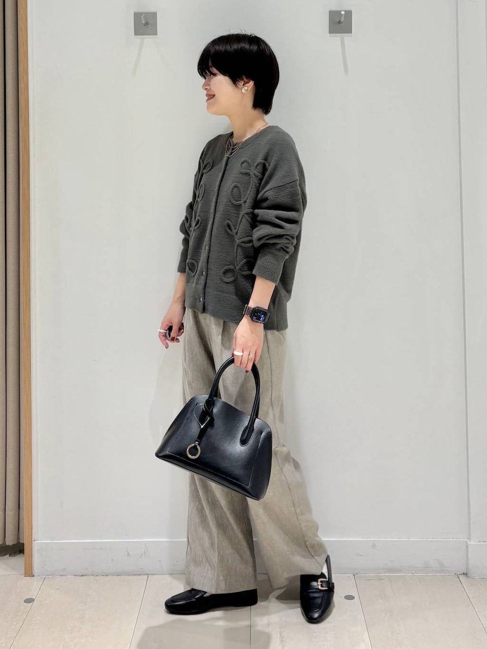 ブラック系のローファー、ブラック系のショルダーバッグ、ベージュ系のその他パンツを着用したレディースの秋コーディネートの2枚目の写真