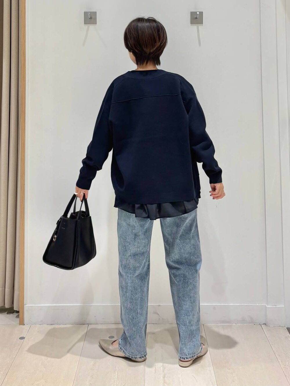 ブルー系のデニムパンツ、ブルー系のカーディガン/ボレロ、ブラック系のトートバッグを着用したレディースの秋コーディネートの3枚目の写真