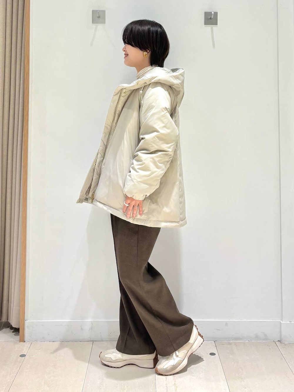 ベージュ系のダウンジャケット/コート、ブラウン系のその他パンツ、ホワイト系のTシャツ/カットソーを着用したレディースの冬コーディネートの2枚目の写真