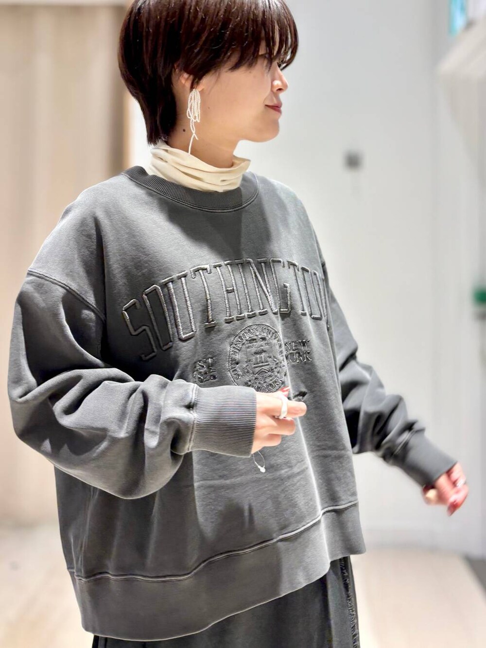 ホワイト系のTシャツ/カットソー、グレー系のスカート、グレー系のスウェットを着用したレディースの秋コーディネートの2枚目の写真