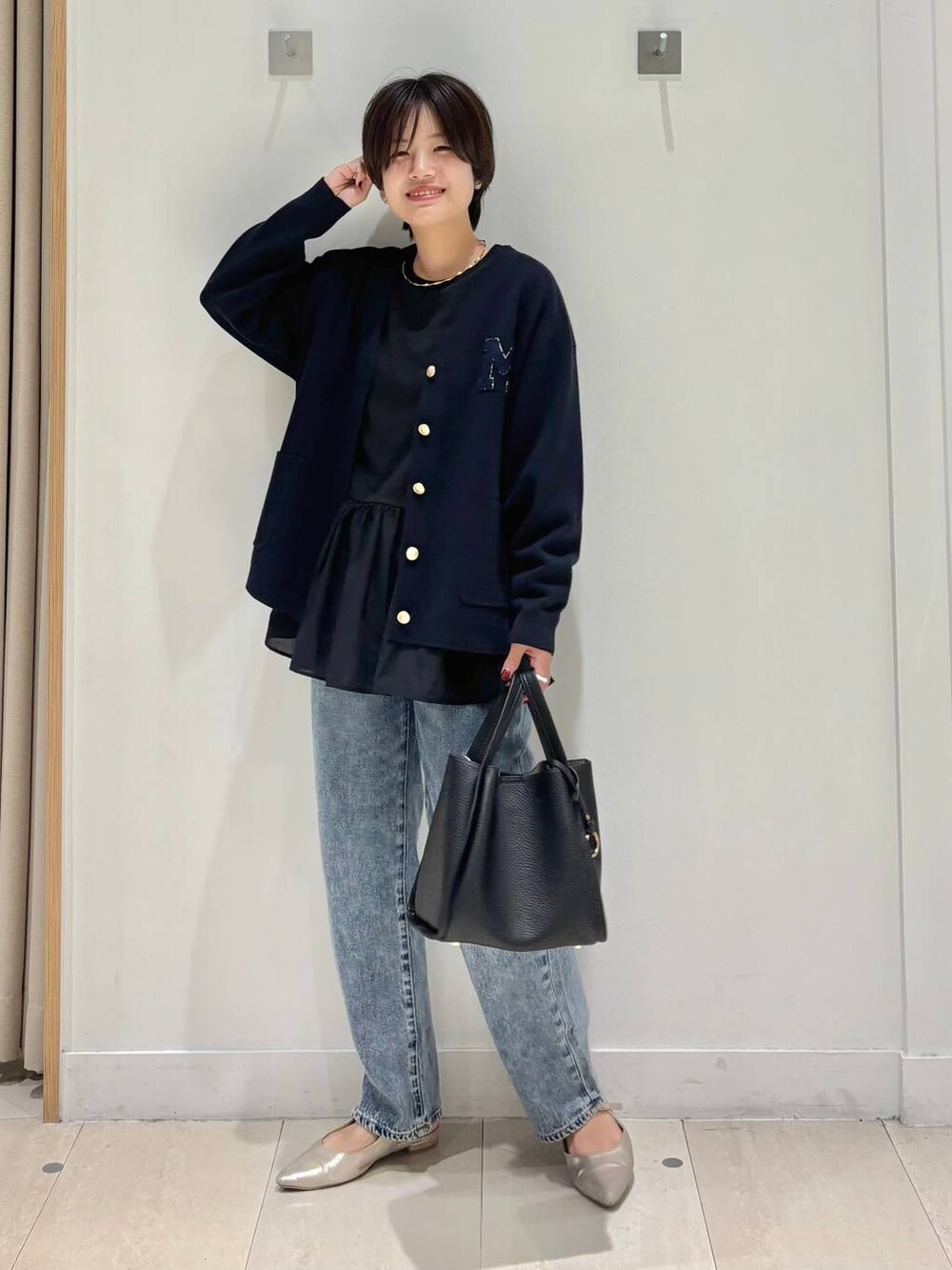 ブルー系のデニムパンツ、ブルー系のカーディガン/ボレロ、ブラック系のトートバッグを着用したレディースの秋コーディネートの5枚目の写真