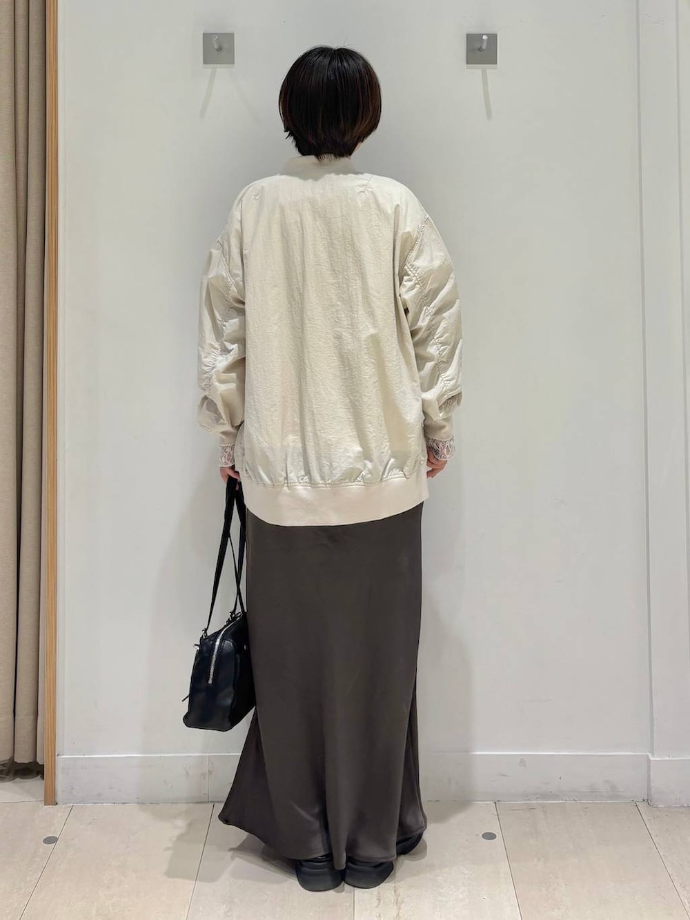 ホワイト系のTシャツ/カットソー、ベージュ系のブルゾン、ブラウン系のスカートを着用したレディースの春コーディネートの4枚目の写真