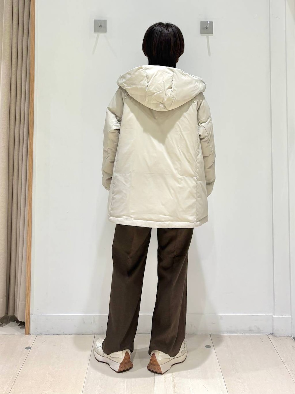 ベージュ系のダウンジャケット/コート、ブラウン系のその他パンツ、ホワイト系のTシャツ/カットソーを着用したレディースの冬コーディネートの3枚目の写真