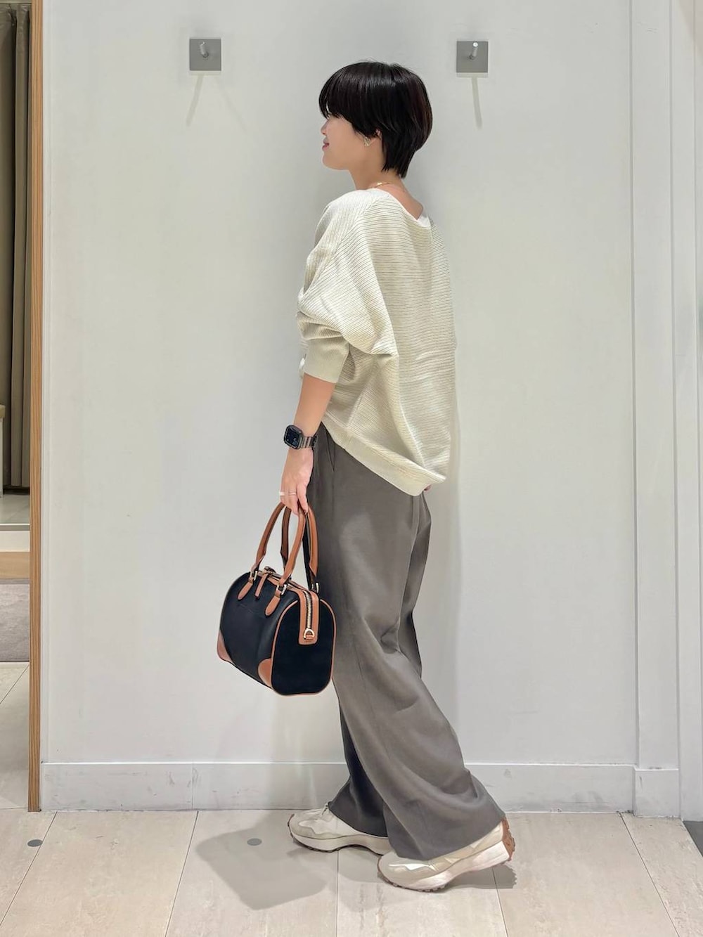 ブラウン系のその他パンツ、グレー系のニット/セーター、ブラック系のボストンバッグを着用したレディースの秋コーディネートの2枚目の写真