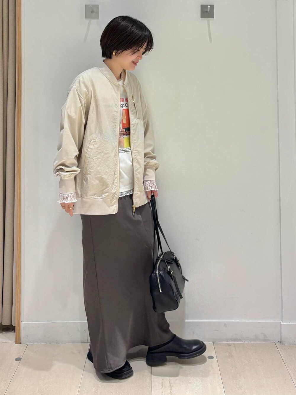 ホワイト系のTシャツ/カットソー、ベージュ系のブルゾン、ブラウン系のスカートを着用したレディースの春コーディネートの5枚目の写真