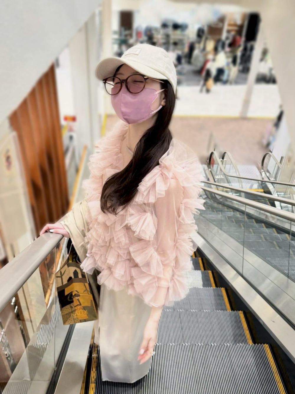 ピンク系のシャツ/ブラウス、ベージュ系のワンピース、ブラウン系のショルダーバッグを着用したレディースの春コーディネートの2枚目の写真