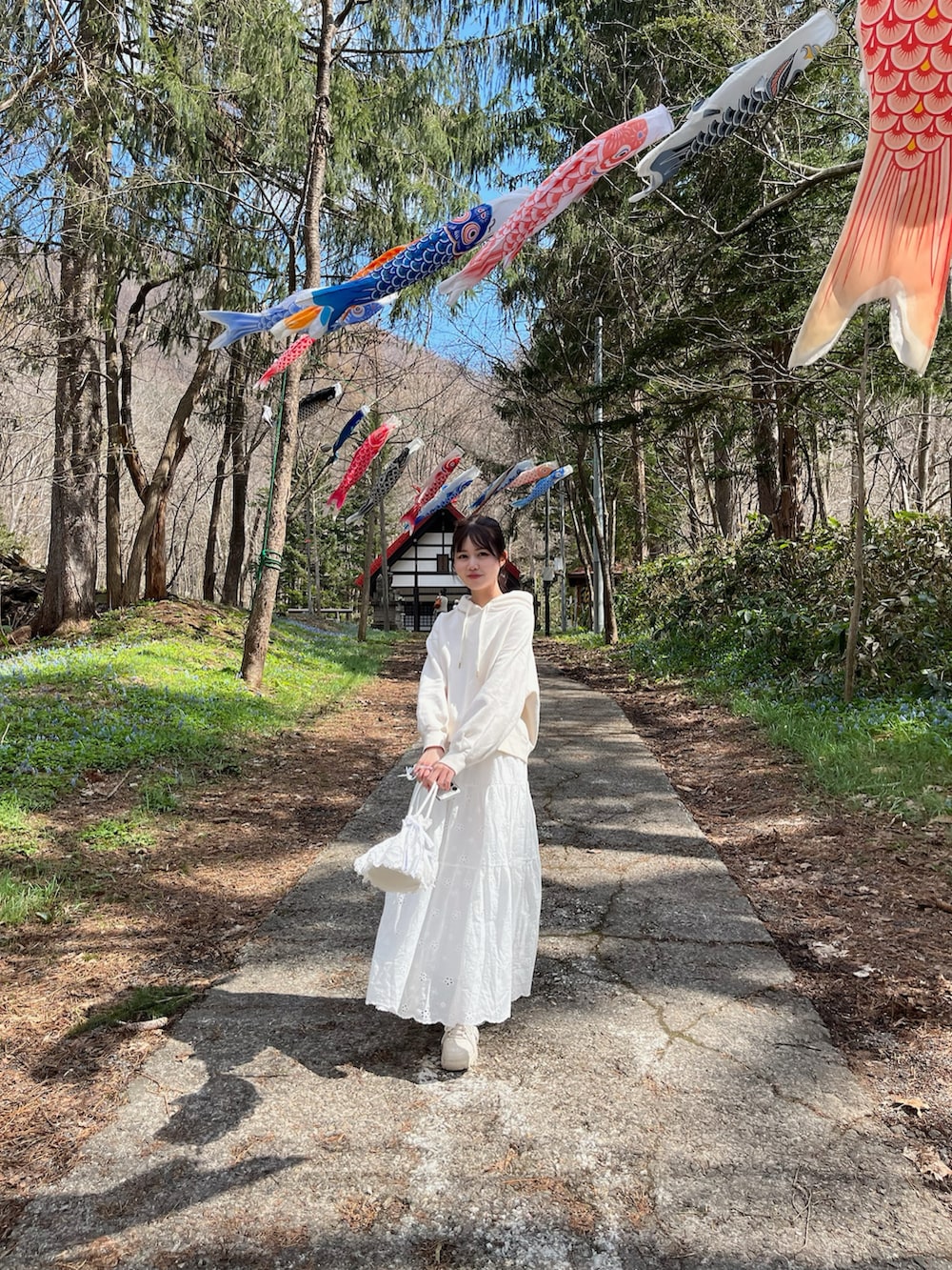 ホワイト系のハンドバッグ、ホワイト系のスカートを着用したレディースの春コーディネートの3枚目の写真