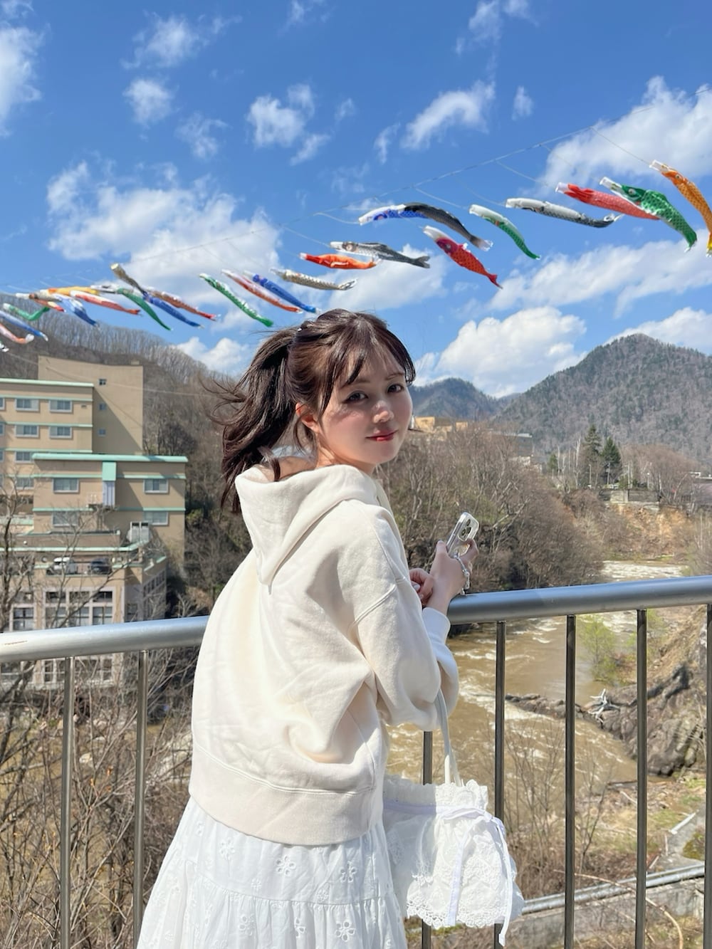 ホワイト系のハンドバッグ、ホワイト系のスカートを着用したレディースの春コーディネートの2枚目の写真