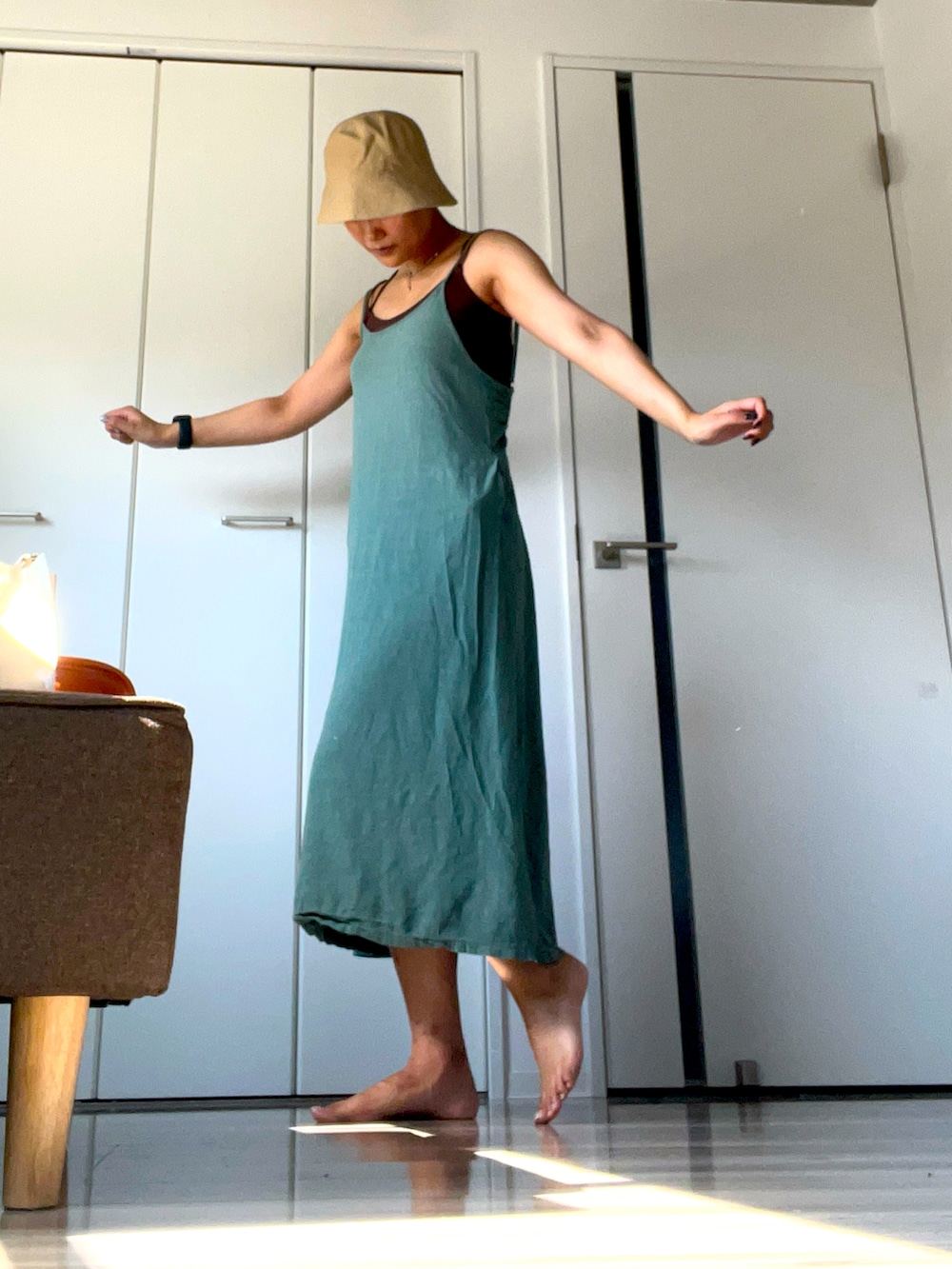 グリーン系のワンピース、ベージュ系の帽子を着用したレディースの夏コーディネートの2枚目の写真