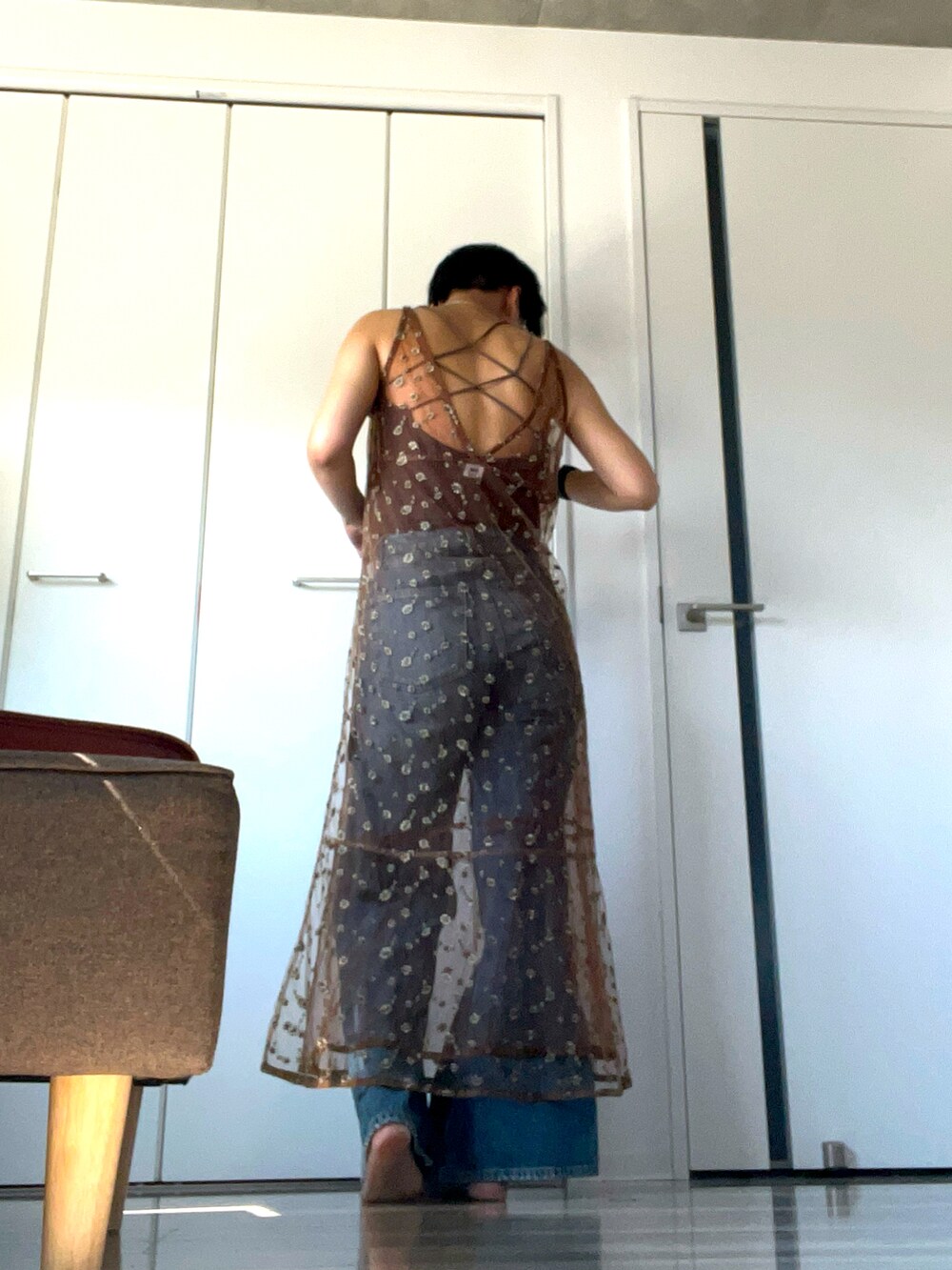 ブラウン系のドレス、ブルー系のデニムパンツ、ブラウン系のキャミソールを着用したレディースの夏コーディネートの2枚目の写真