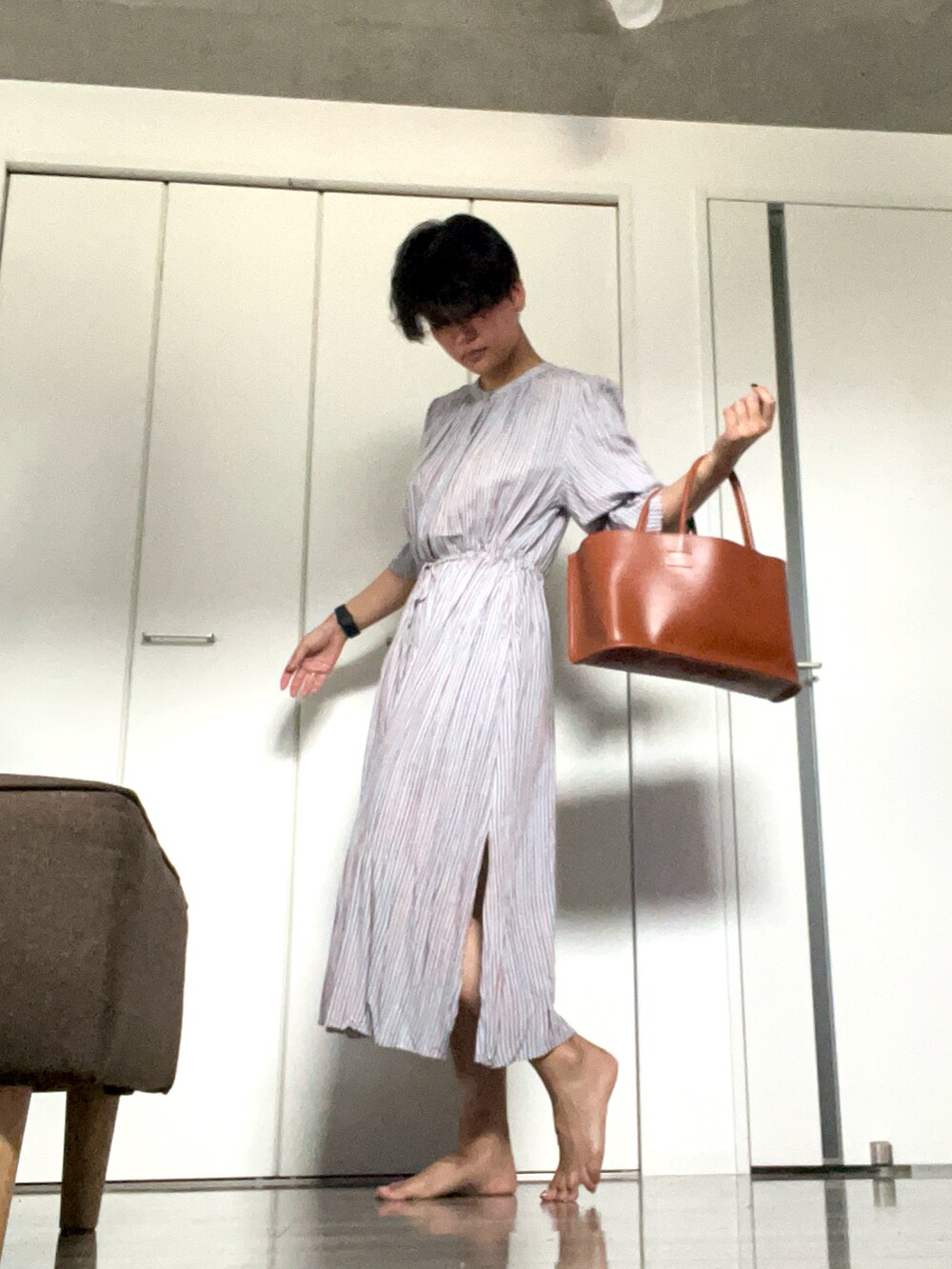 ブルー系のワンピース、イエロー系のハンドバッグを着用したレディースの夏コーディネートの2枚目の写真