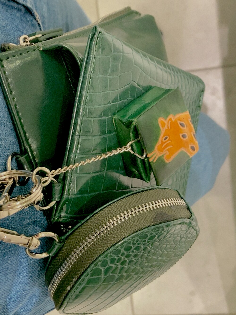 グリーン系のショルダーバッグ、グリーン系のキーホルダーを着用したレディースの冬コーディネートの2枚目の写真