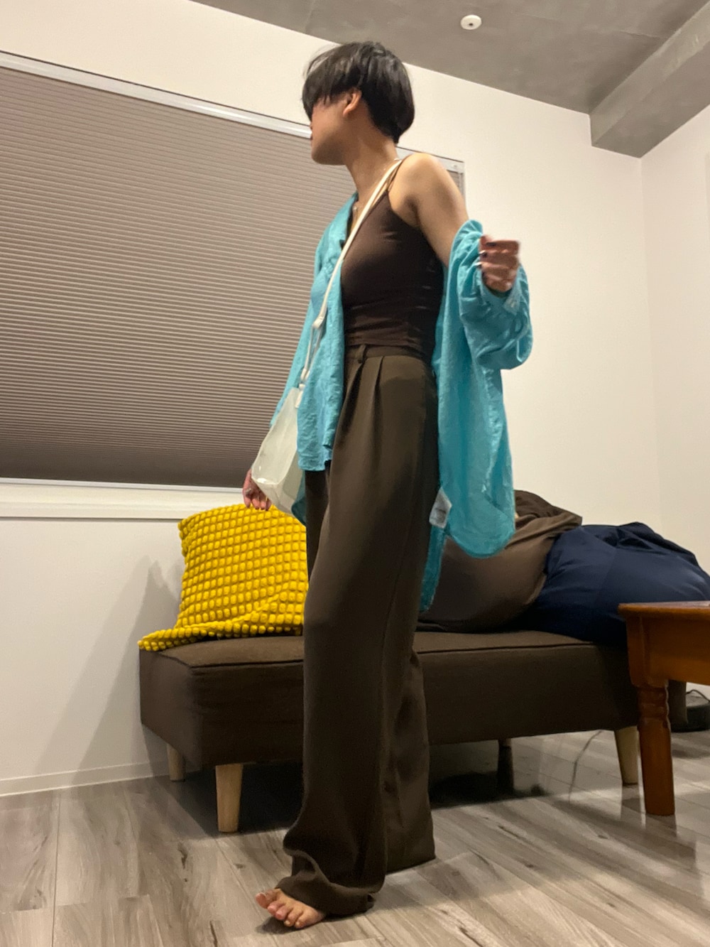 ブラウン系のスラックス、ブルー系のトップス、ホワイト系のショルダーバッグを着用したレディースの夏コーディネートの2枚目の写真