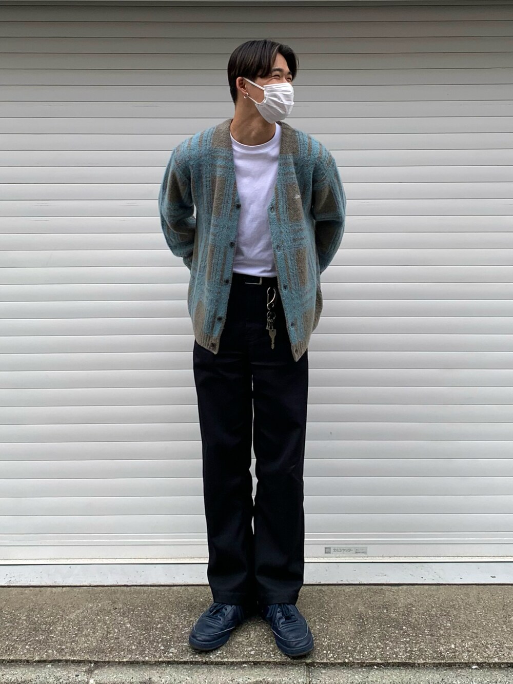 ブラック系のチノパンツ、ブルー系のスニーカー、ホワイト系のTシャツ/カットソーを着用したメンズの春コーディネートの2枚目の写真