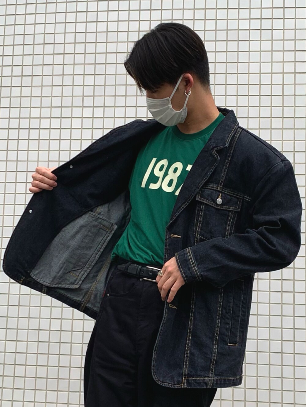 グリーン系のTシャツ/カットソー、ブラック系のデニムジャケット、ブラック系のチノパンツを着用したメンズの春コーディネートの2枚目の写真