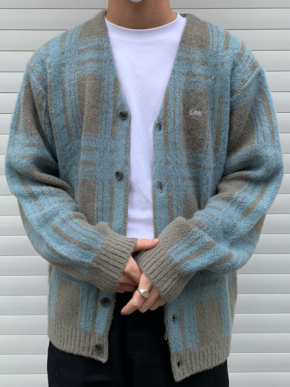 ブラック系のチノパンツ、ブルー系のスニーカー、ホワイト系のTシャツ/カットソーを着用したメンズの春コーディネートの3枚目の写真
