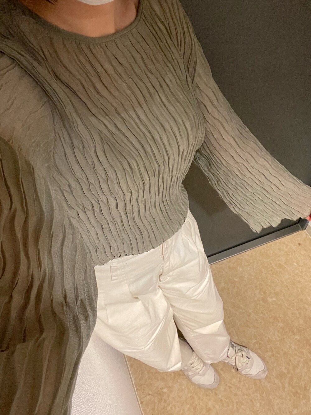 ホワイト系のスラックス、ホワイト系のスニーカー、ホワイト系のカーディガン/ボレロを着用したレディースの春コーディネートの2枚目の写真