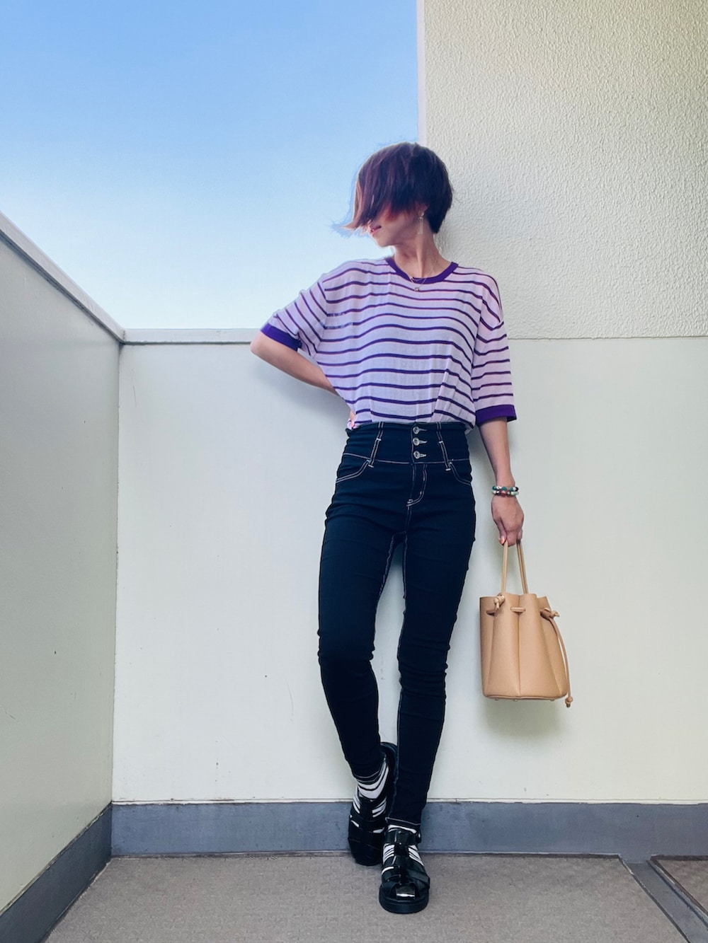 ブラック系のデニムパンツ、ブラック系のバッグ、グリーン系のテーラードジャケットを着用したレディースの秋コーディネートの2枚目の写真