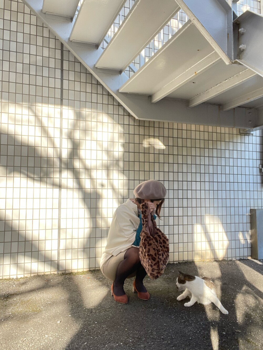 ブラウン系のパンプス、ブラウン系のバッグ、ホワイト系のトップスを着用したレディースの秋コーディネートの3枚目の写真