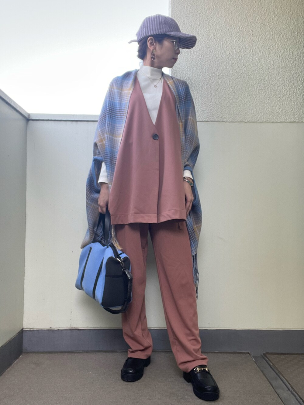 ブラウン系のパンツ、ブルー系のトートバッグ、ホワイト系のニット/セーターを着用したレディースの春コーディネートの2枚目の写真