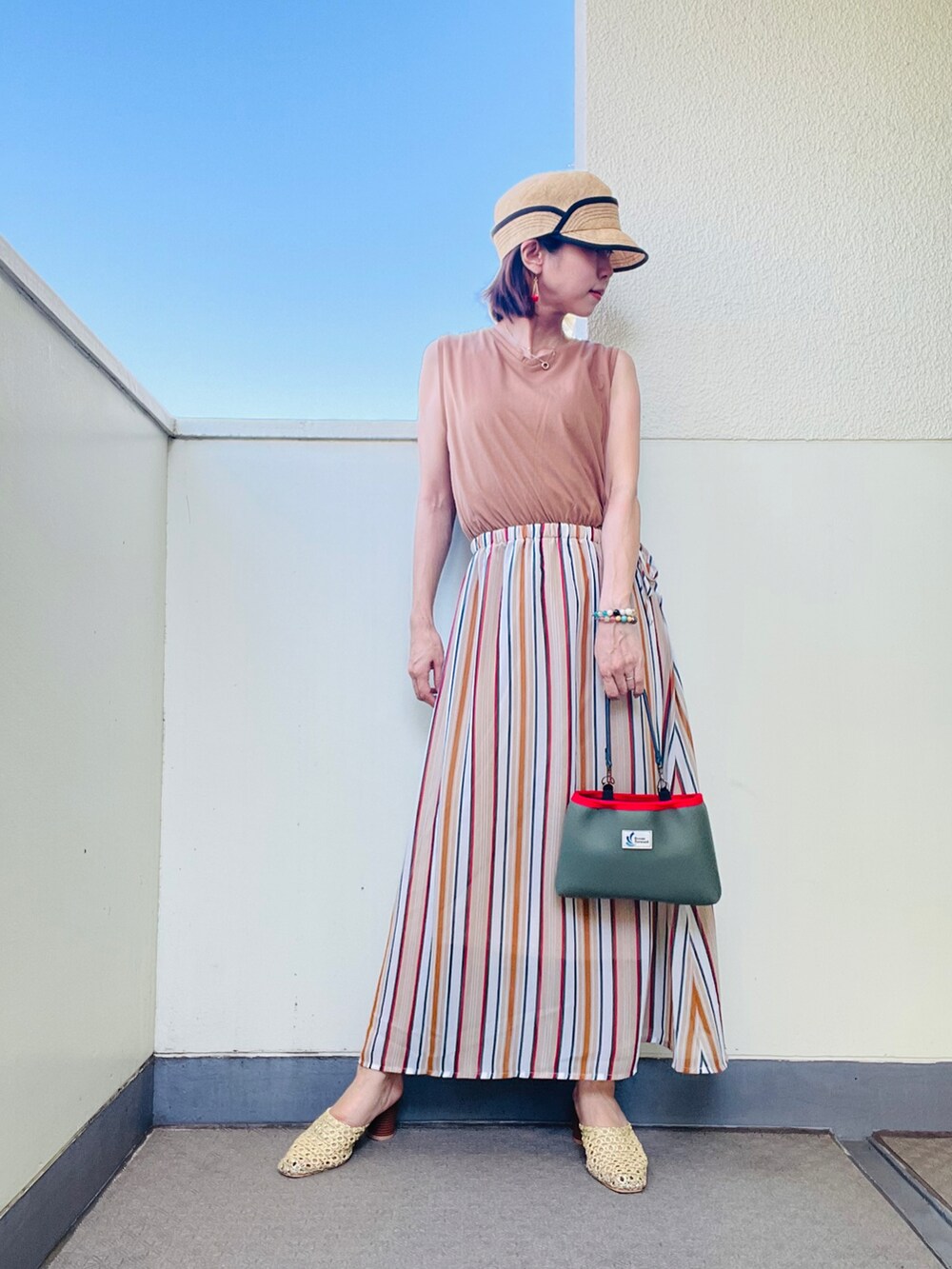 ホワイト系のシャツ/ブラウス、ベージュ系のワンピース、ゴールド系のサンダルを着用したレディースの夏コーディネートの2枚目の写真