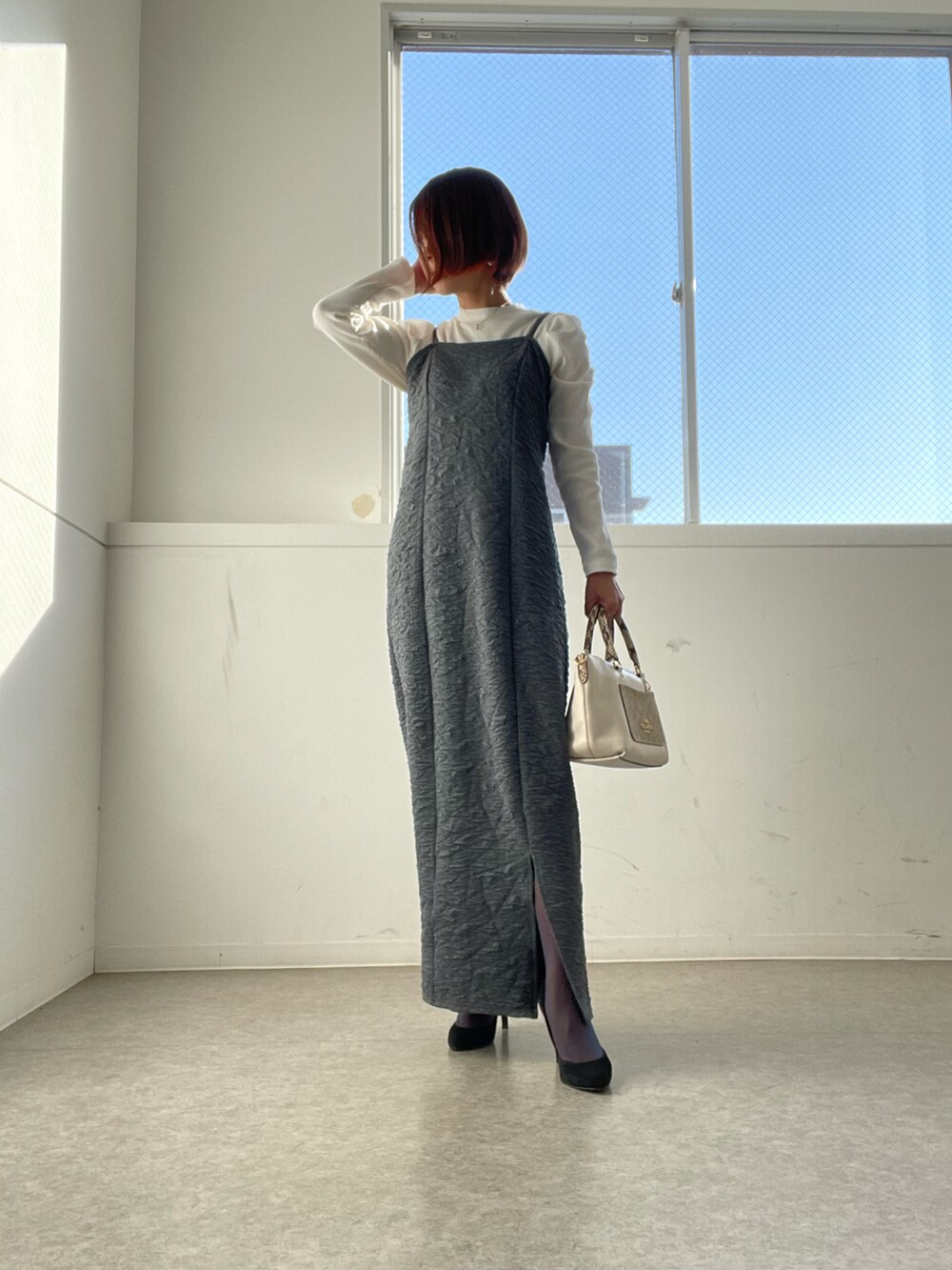 ホワイト系のバッグ、グレー系のワンピース、ホワイト系のニット/セーターを着用したレディースの秋コーディネートの3枚目の写真