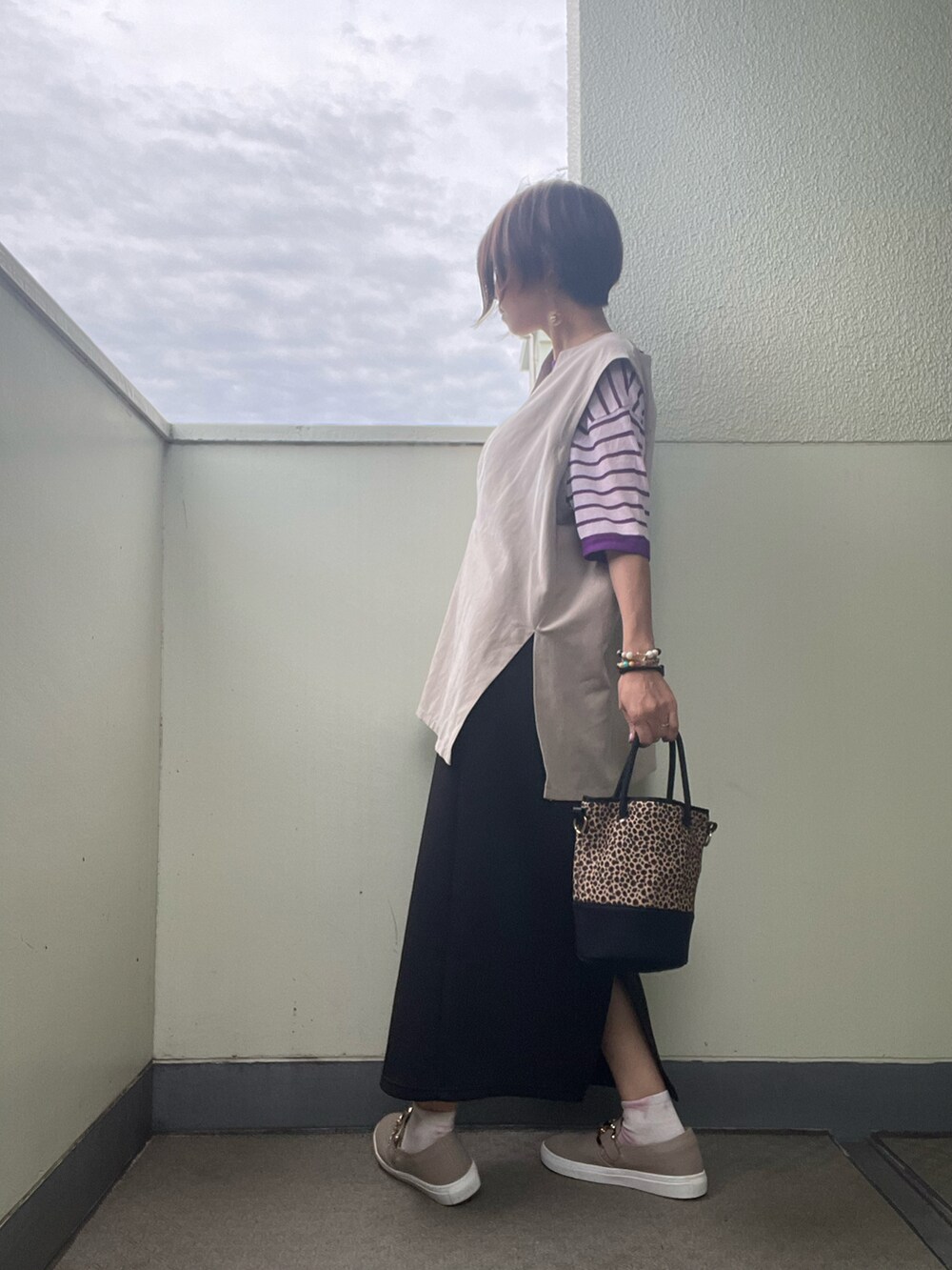 ブラック系のスカート、ブラック系のバッグ、その他のスニーカーを着用したレディースの秋コーディネートの2枚目の写真