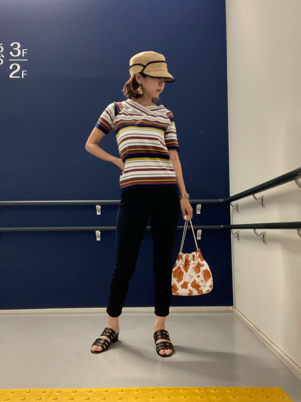 ブラック系のサンダル、ホワイト系のショルダーバッグ、ブラック系のパンツを着用したレディースの夏コーディネートの2枚目の写真