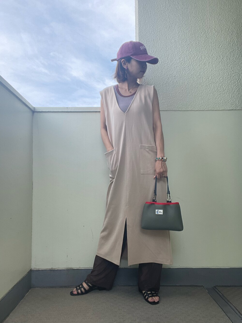 ベージュ系のワンピース/ドレス、グリーン系のバッグ、ブラウン系のタンクトップを着用したレディースの夏コーディネートの2枚目の写真