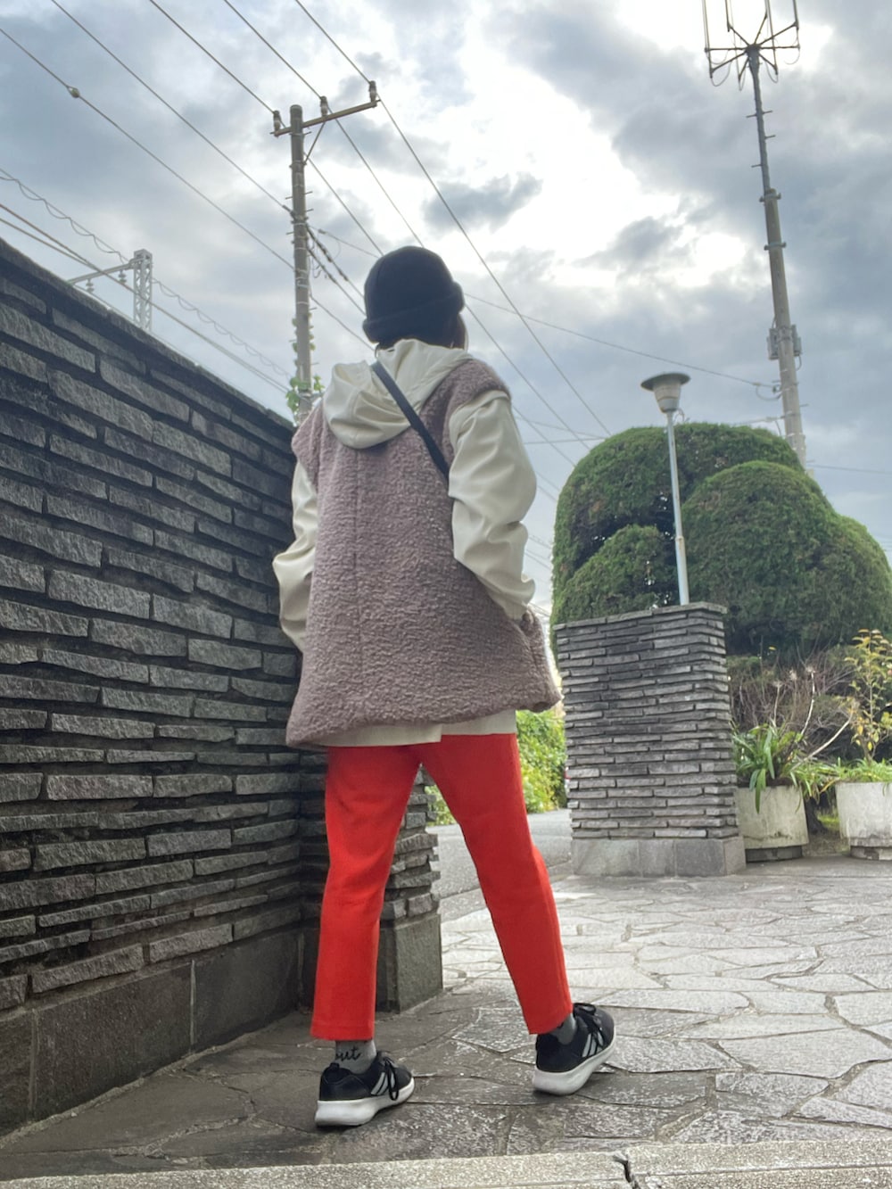 オレンジ系のその他パンツ、ブラック系のTシャツ/カットソー、ホワイト系のブルゾンを着用したレディースの冬コーディネートの3枚目の写真