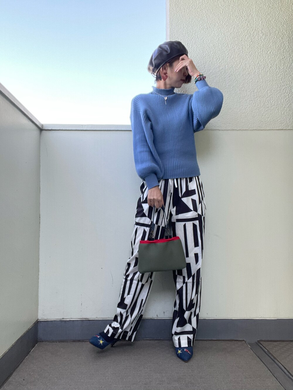 ブラック系のベスト、ホワイト系のその他パンツ、ブルー系のパンプスを着用したレディースの秋コーディネートの2枚目の写真