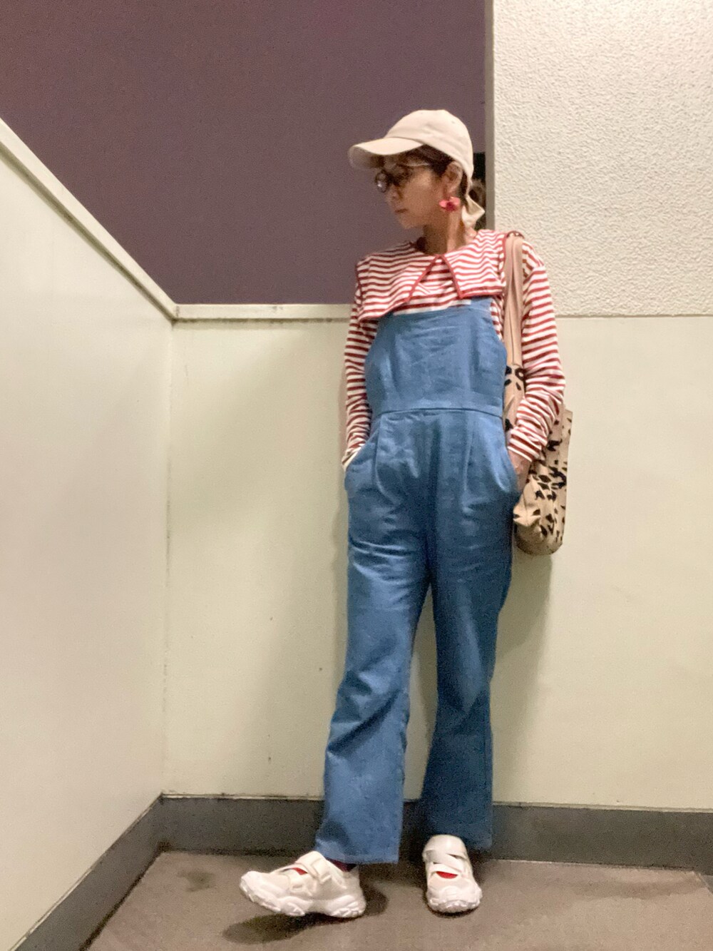 ブルー系のサロペット/オーバーオール、ホワイト系のシューズ、ブラウン系のバッグを着用したレディースの春コーディネートの2枚目の写真