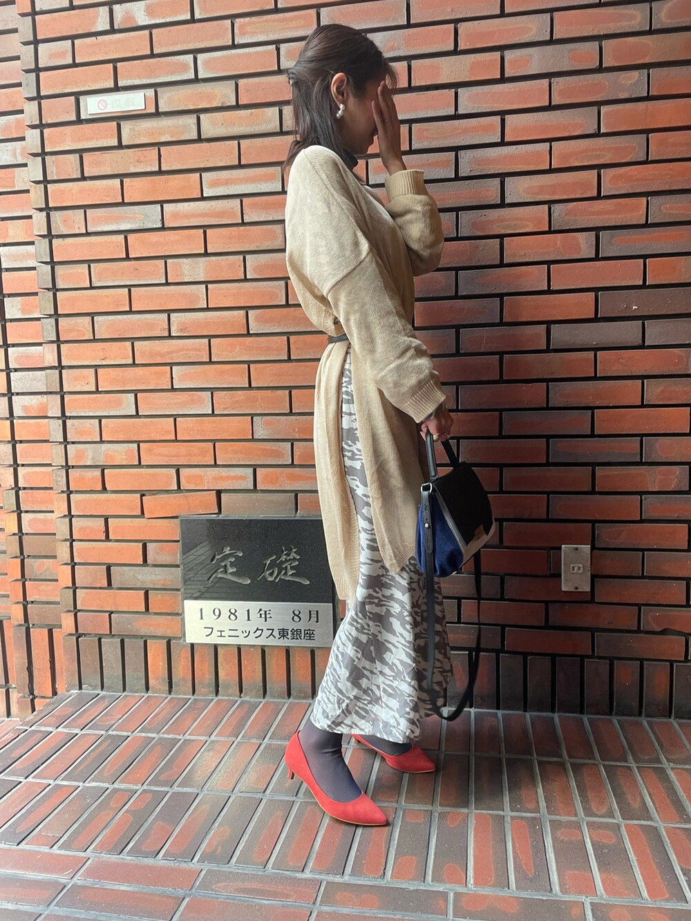 レッド系のパンプス、その他のワンピース、ベージュ系のニット/セーターを着用したレディースの春コーディネートの2枚目の写真