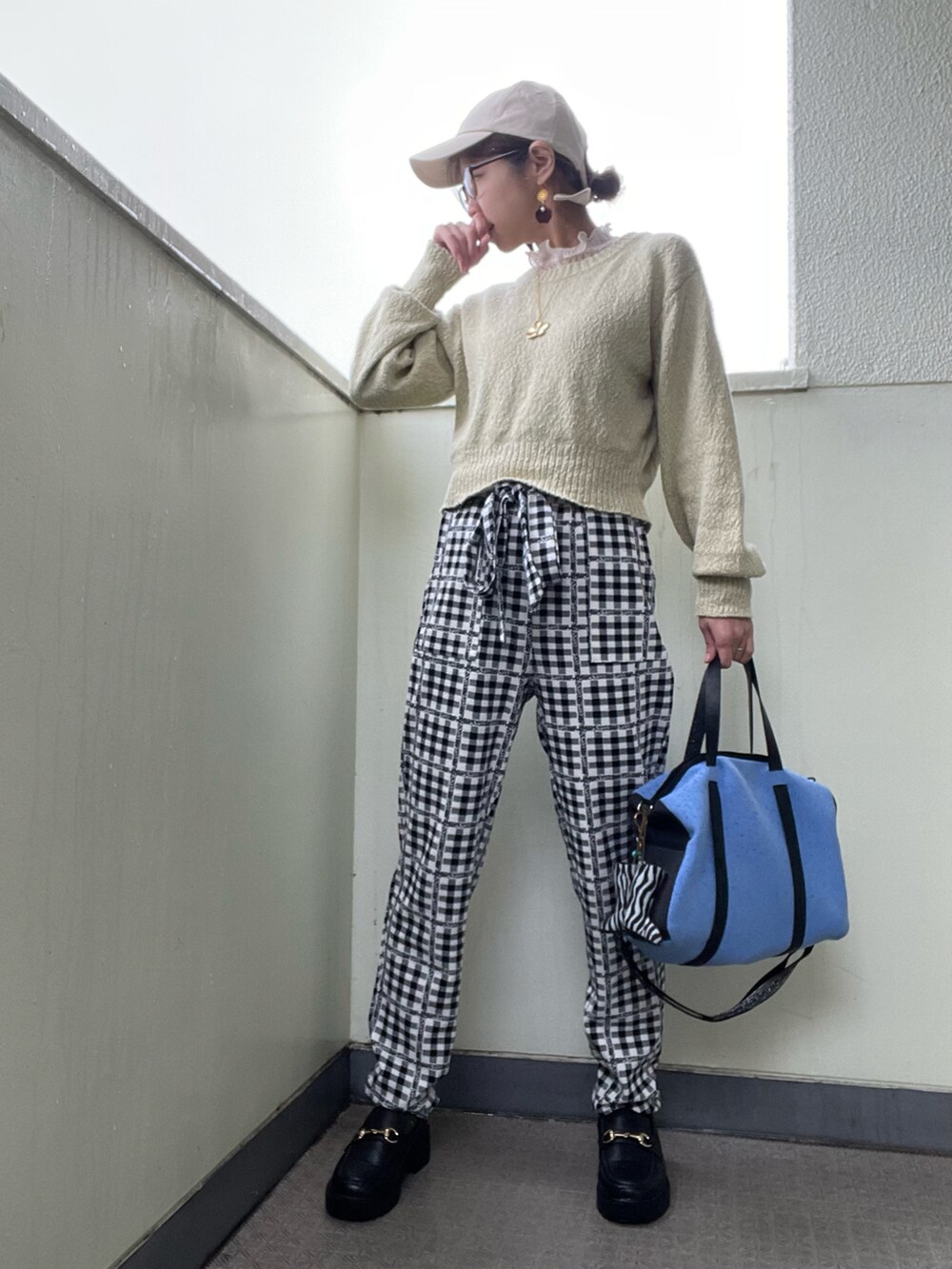 ブラック系のローファー、ブルー系のトートバッグ、ブラック系のパンツを着用したレディースの春コーディネートの2枚目の写真