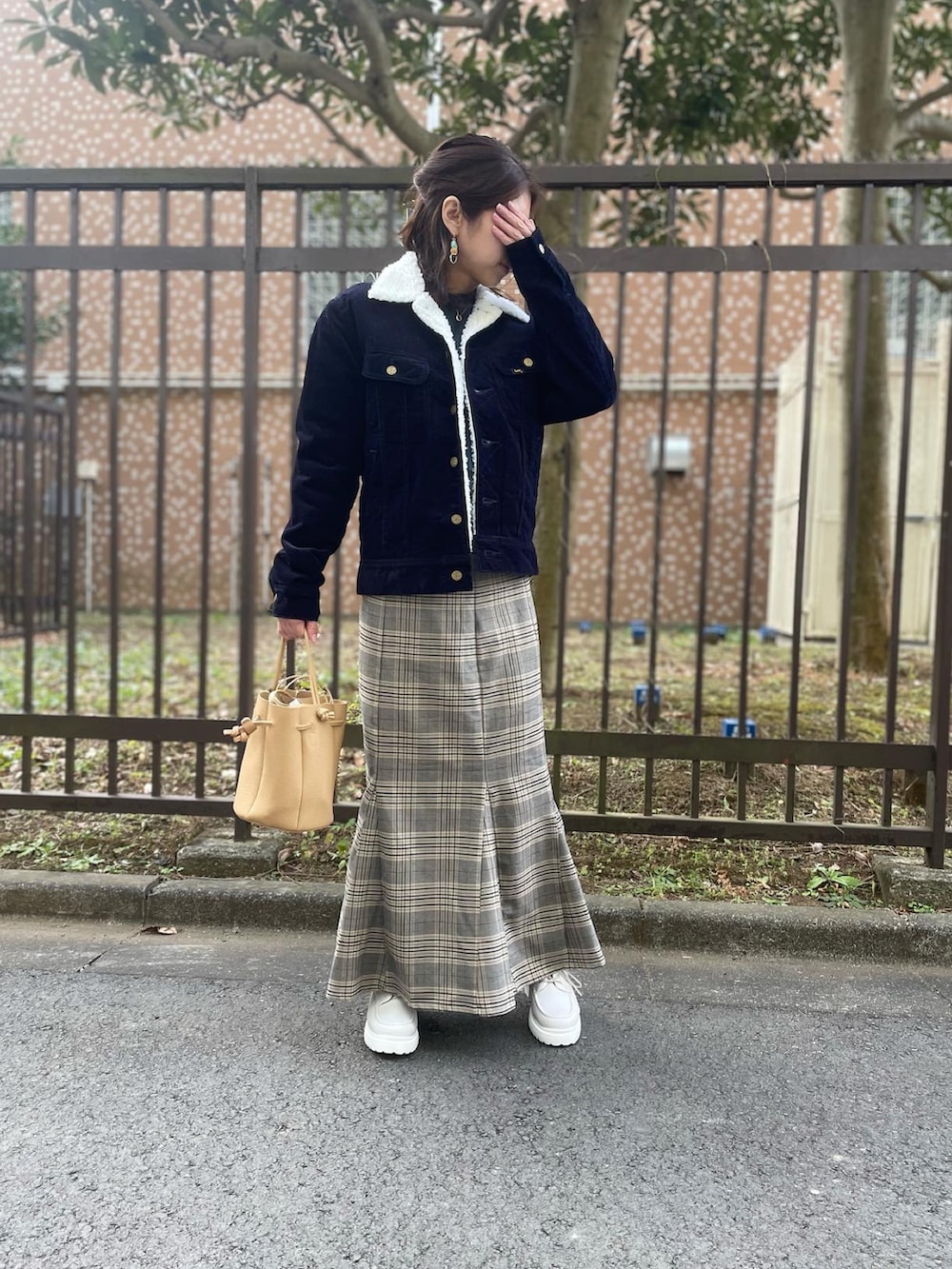 ホワイト系のスニーカー、ブラウン系のスカート、グリーン系のトップスを着用したレディースの冬コーディネートの2枚目の写真