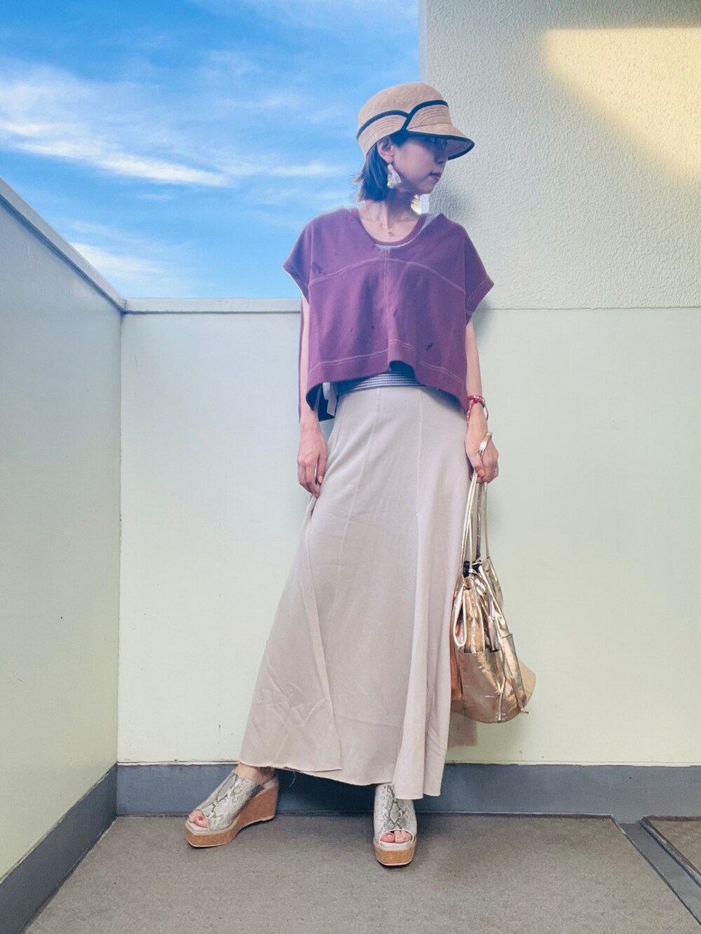 ブラウン系のベスト、ホワイト系のスカート、グレー系のサンダルを着用したレディースの夏コーディネートの2枚目の写真