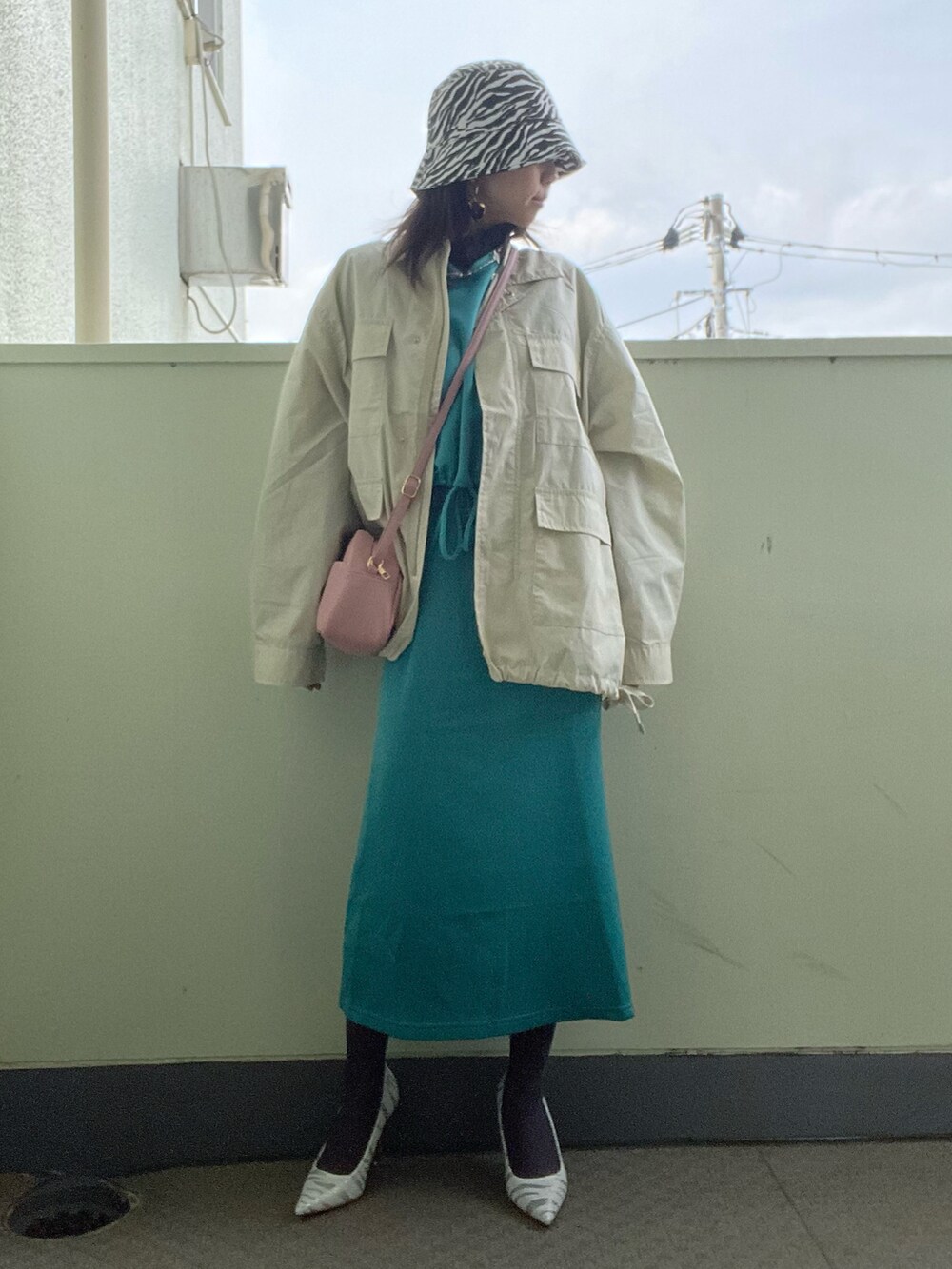 ピンク系のショルダーバッグ、グリーン系のワンピース/ドレス、ホワイト系のパンプスを着用したレディースの春コーディネートの2枚目の写真