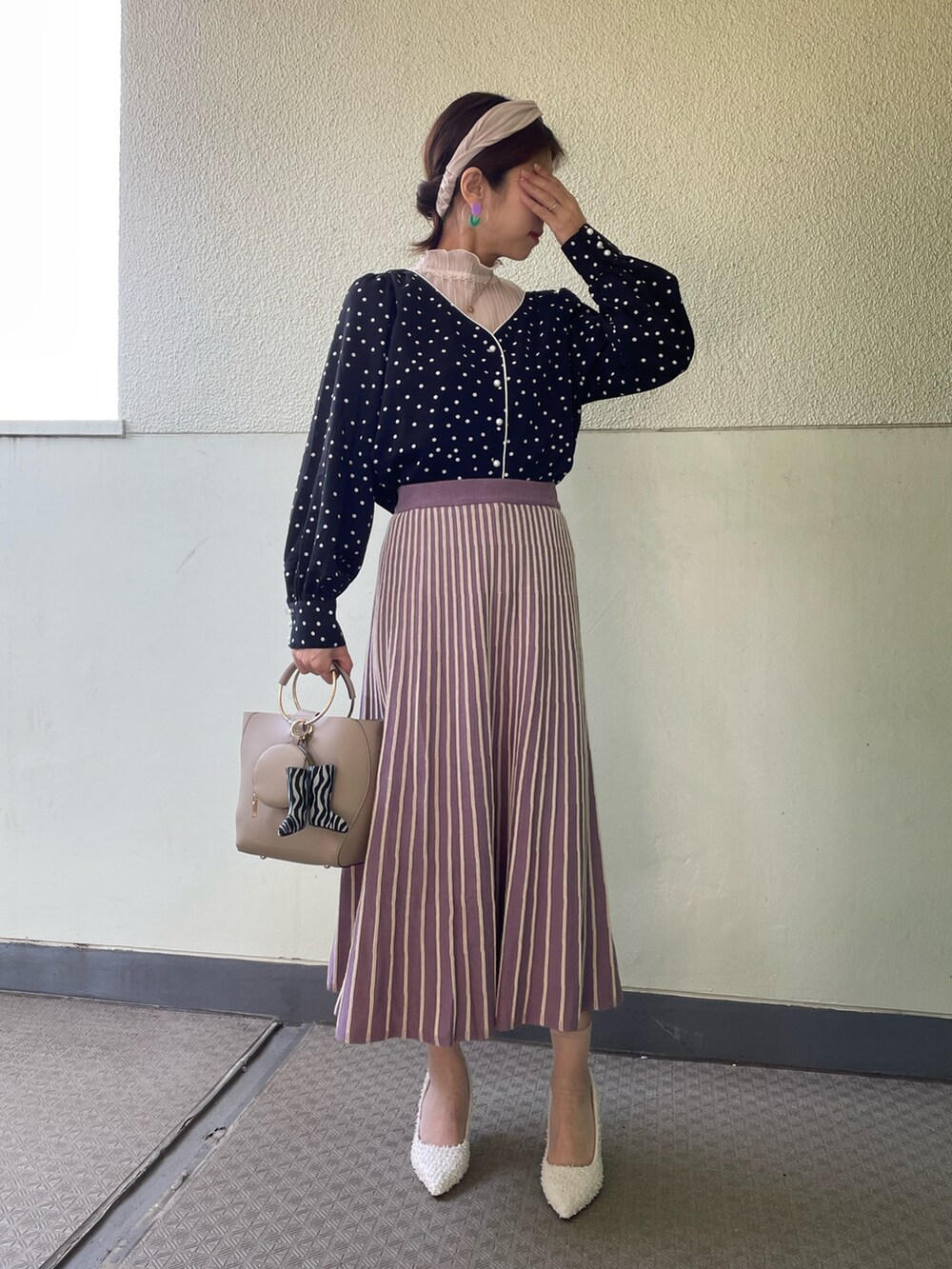 ホワイト系のパンプス、ベージュ系のバッグ、その他のシャツ/ブラウスを着用したレディースの春コーディネートの2枚目の写真