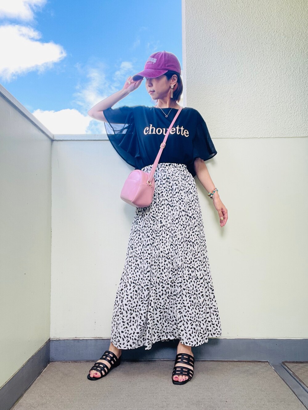 ブラック系のサンダル、ホワイト系のスカート、ホワイト系のTシャツ/カットソーを着用したレディースの夏コーディネートの2枚目の写真