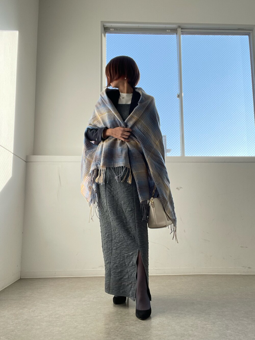 ホワイト系のバッグ、グレー系のワンピース、ホワイト系のニット/セーターを着用したレディースの秋コーディネートの2枚目の写真