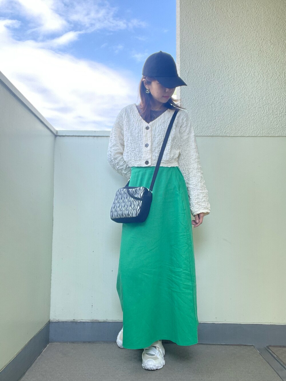 ホワイト系のシューズ、グリーン系のスカート、ホワイト系のショルダーバッグを着用したレディースの春コーディネートの3枚目の写真
