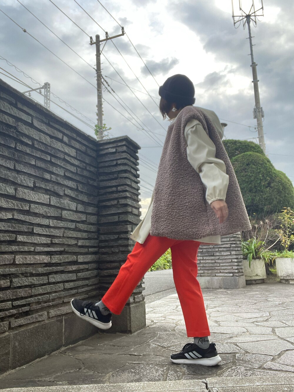 オレンジ系のその他パンツ、ブラック系のTシャツ/カットソー、ホワイト系のブルゾンを着用したレディースの冬コーディネートの2枚目の写真