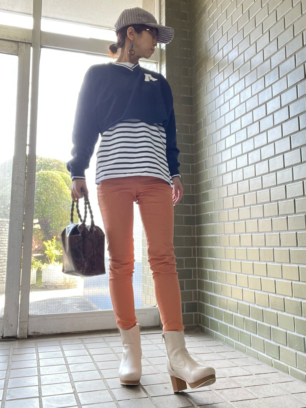 ホワイト系のブーツ、オレンジ系のパンツ、ブルー系のTシャツ/カットソーを着用したレディースの春コーディネートの2枚目の写真