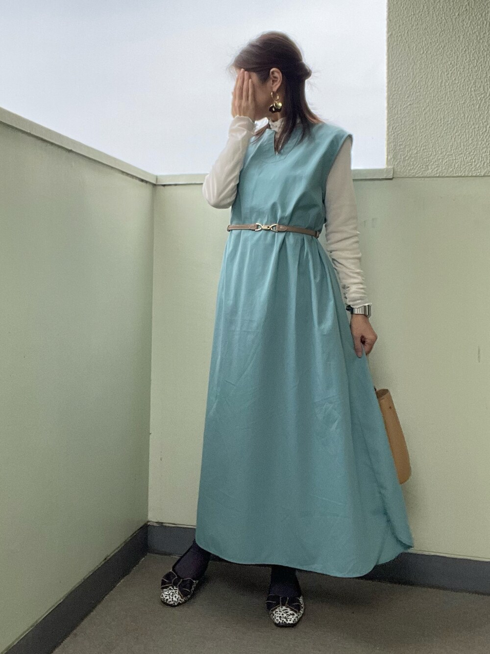 ブルー系のワンピース、ブラック系のバッグ、ホワイト系のカーディガン/ボレロを着用したレディースの春コーディネートの2枚目の写真