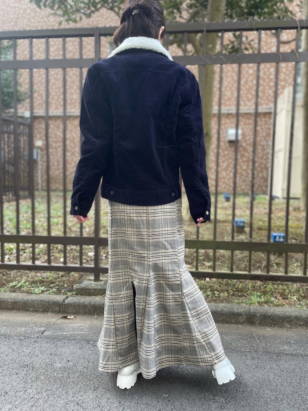 ホワイト系のスニーカー、ブラウン系のスカート、グリーン系のトップスを着用したレディースの冬コーディネートの3枚目の写真