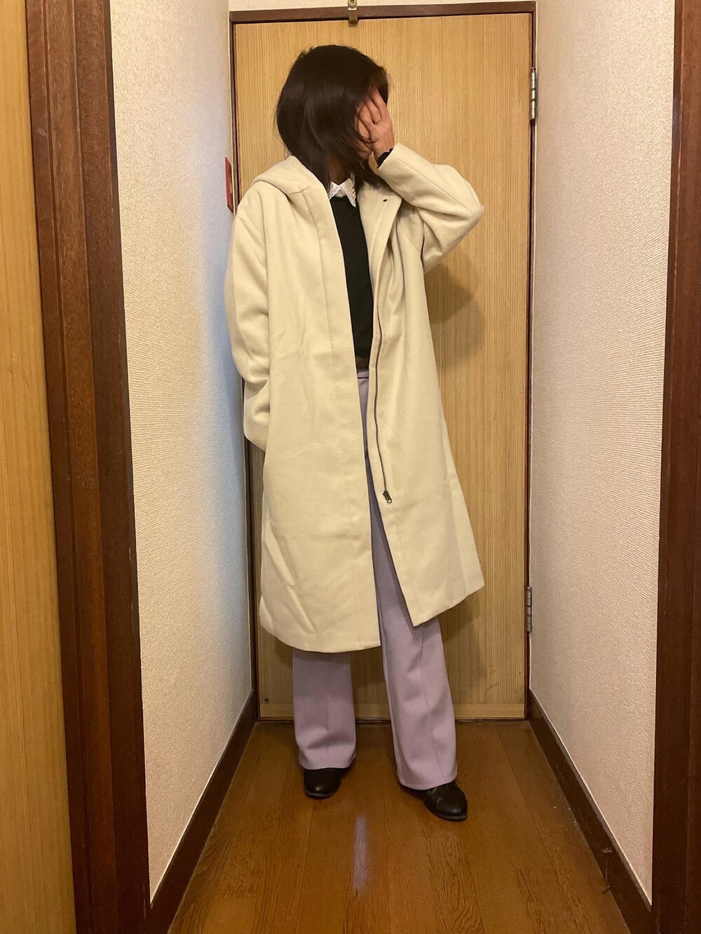 ピンク系のパンツ、ブラック系のトップス、ベージュ系のステンカラーコートを着用したレディースの冬コーディネートの2枚目の写真