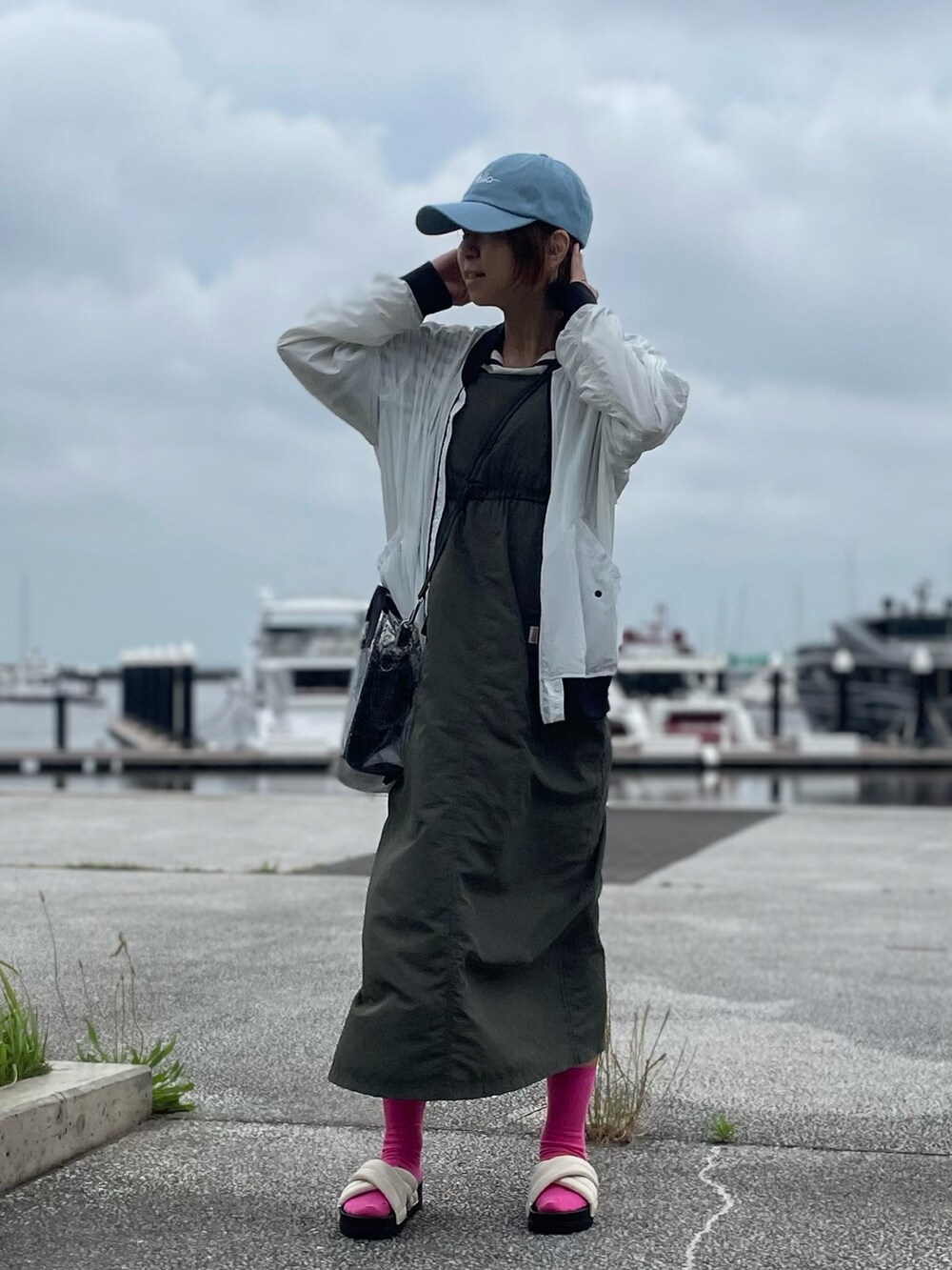 グリーン系のワンピース、ホワイト系のサンダル、ホワイト系のMA-1を着用したレディースの夏コーディネートの2枚目の写真