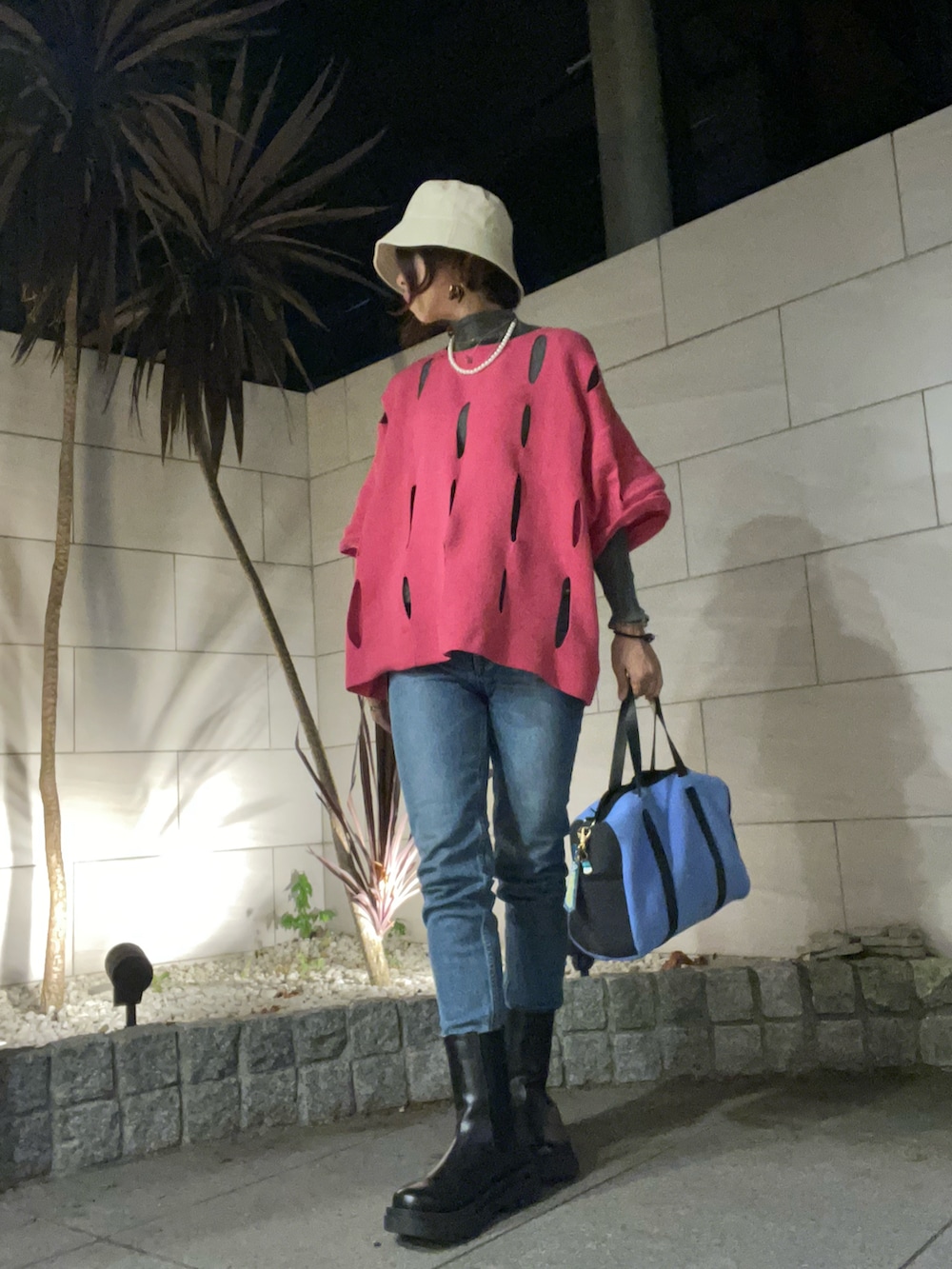 ブルー系のトートバッグ、ブラック系のブーツ、ブルー系のデニムパンツを着用したレディースの秋コーディネートの2枚目の写真