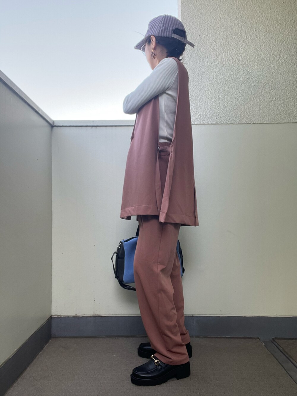 ブラウン系のパンツ、ブルー系のトートバッグ、ホワイト系のニット/セーターを着用したレディースの春コーディネートの3枚目の写真